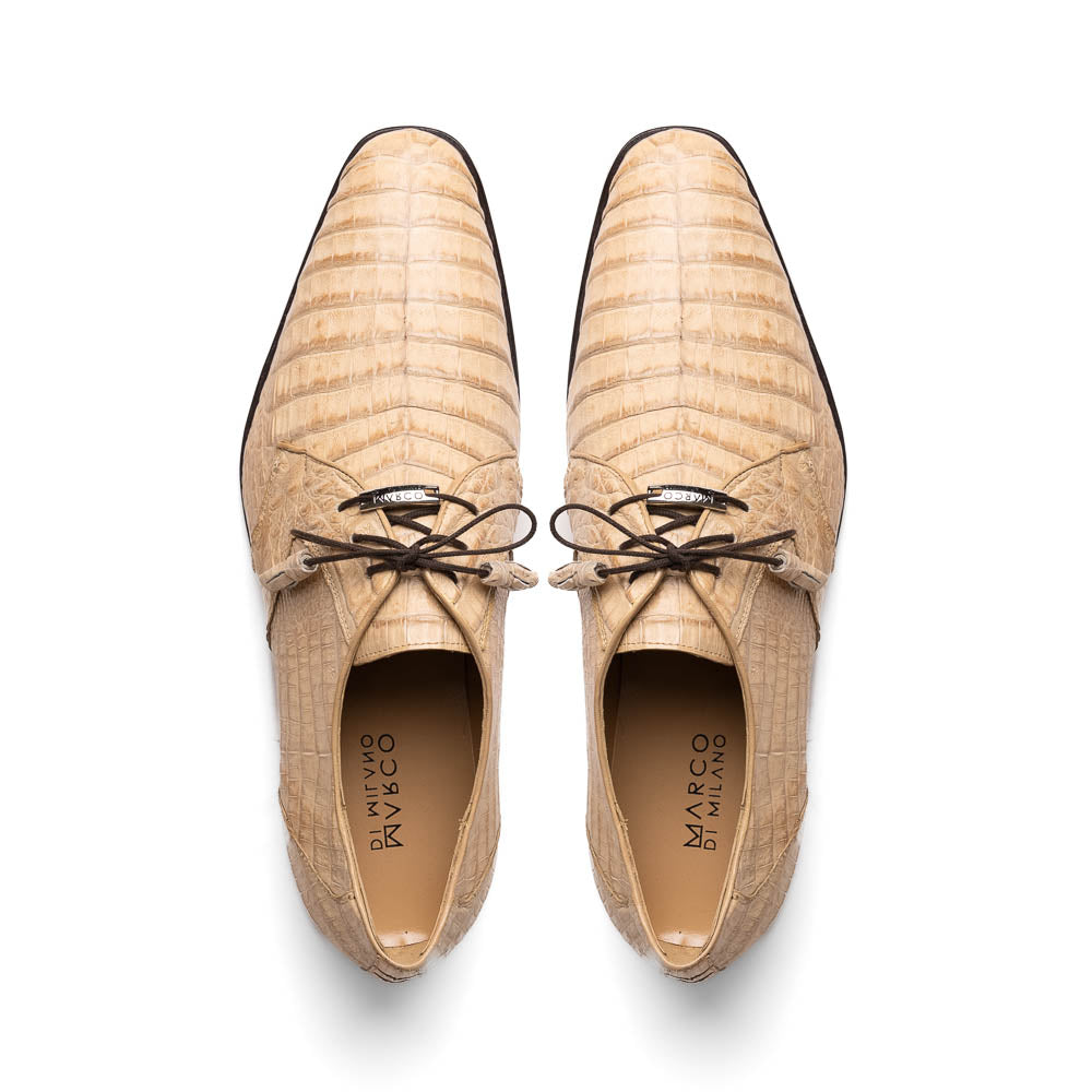 A pair of beige Marco Di Milano Lacio Orix shoes in genuine caiman crocodile, featuring a luxury derby design with dark brown laces—one upright, the other on its side to display the detailed sole.