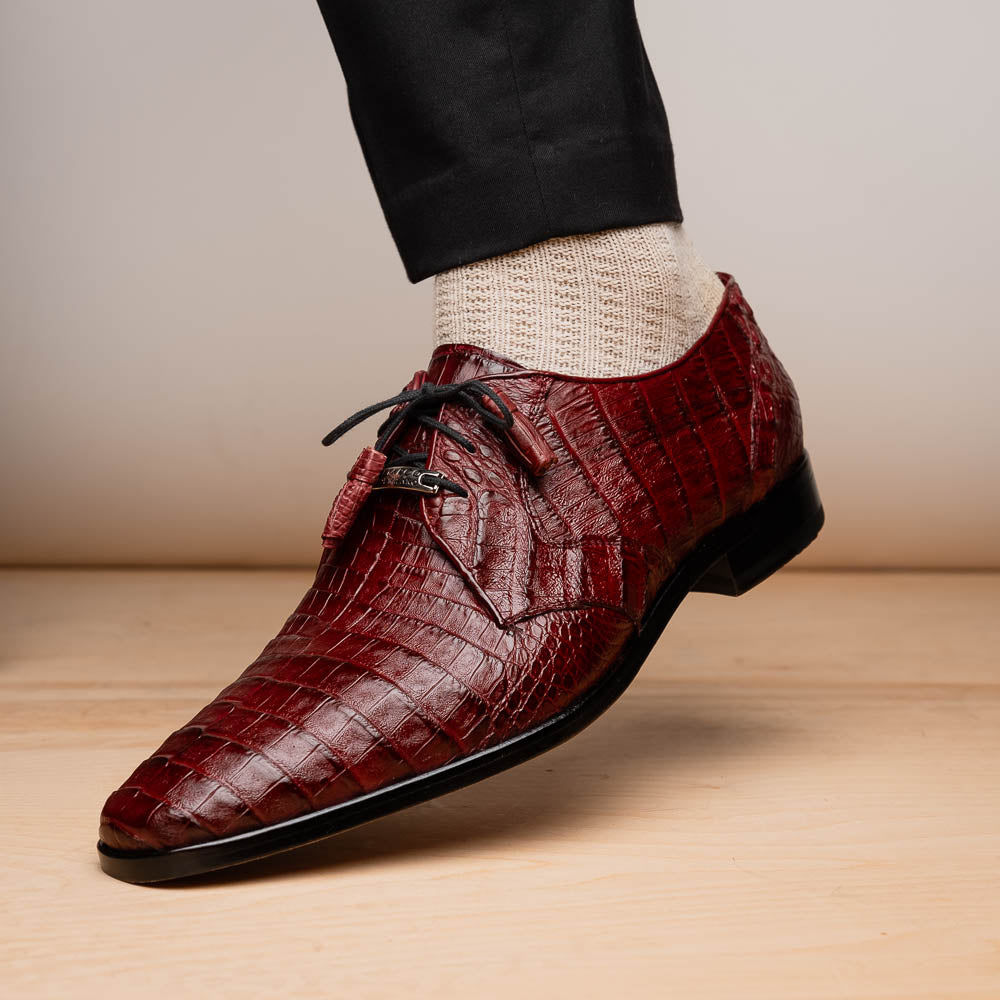 The Lacio Wine by Marco Di Milano is a luxury men's dress shoe crafted from brown genuine caiman crocodile leather, featuring a red inner lining, black laces, and "Marco Di Milano" branding on the tan leather sole.