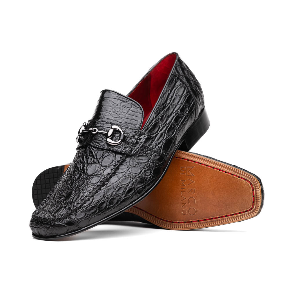 A pair of Marco Di Milano Landro Black crocodile-pattern luxury loafers with metal bit detail: one shoe stands upright, the other lies on its side displaying the tan sole labeled "Marco Di Milano.