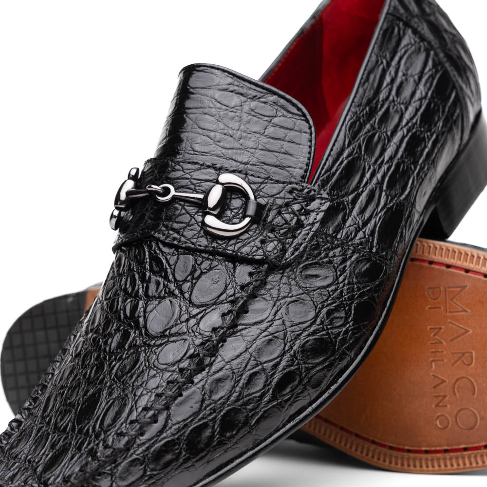 A pair of Marco Di Milano Landro Black crocodile-pattern luxury loafers with metal bit detail: one shoe stands upright, the other lies on its side displaying the tan sole labeled "Marco Di Milano.