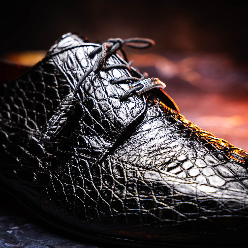 A pair of Marco Di Milano Leonardo Black luxury derby shoes in genuine caiman crocodile leather—one shoe upright, the other showing the tan sole with "Marco di Milano" text.