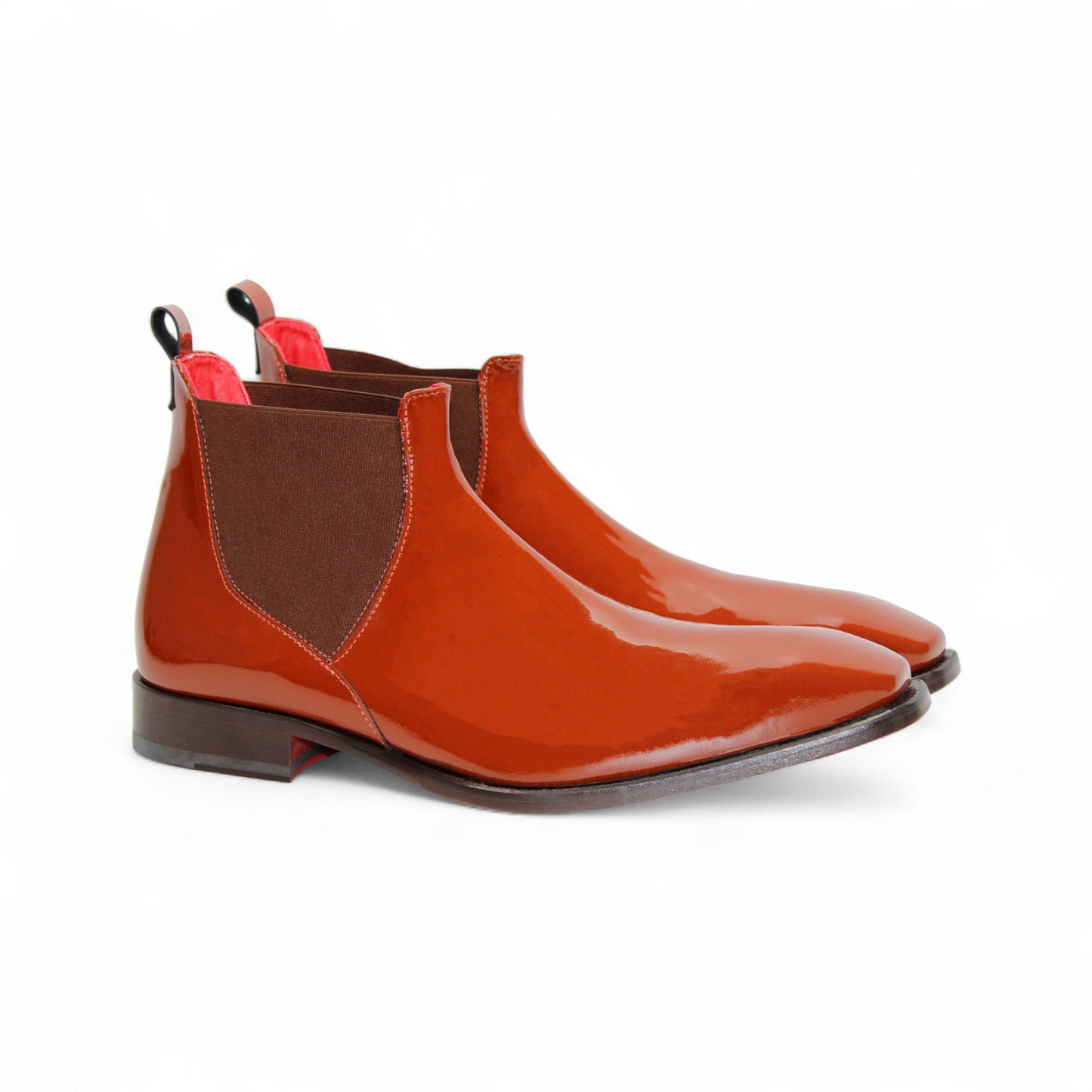 The Emilio Franco Leonardo Brandy is a shiny brown leather Chelsea boot with an elastic side panel, pull tab, and low heel by Emilio Franco, displayed on a white background.