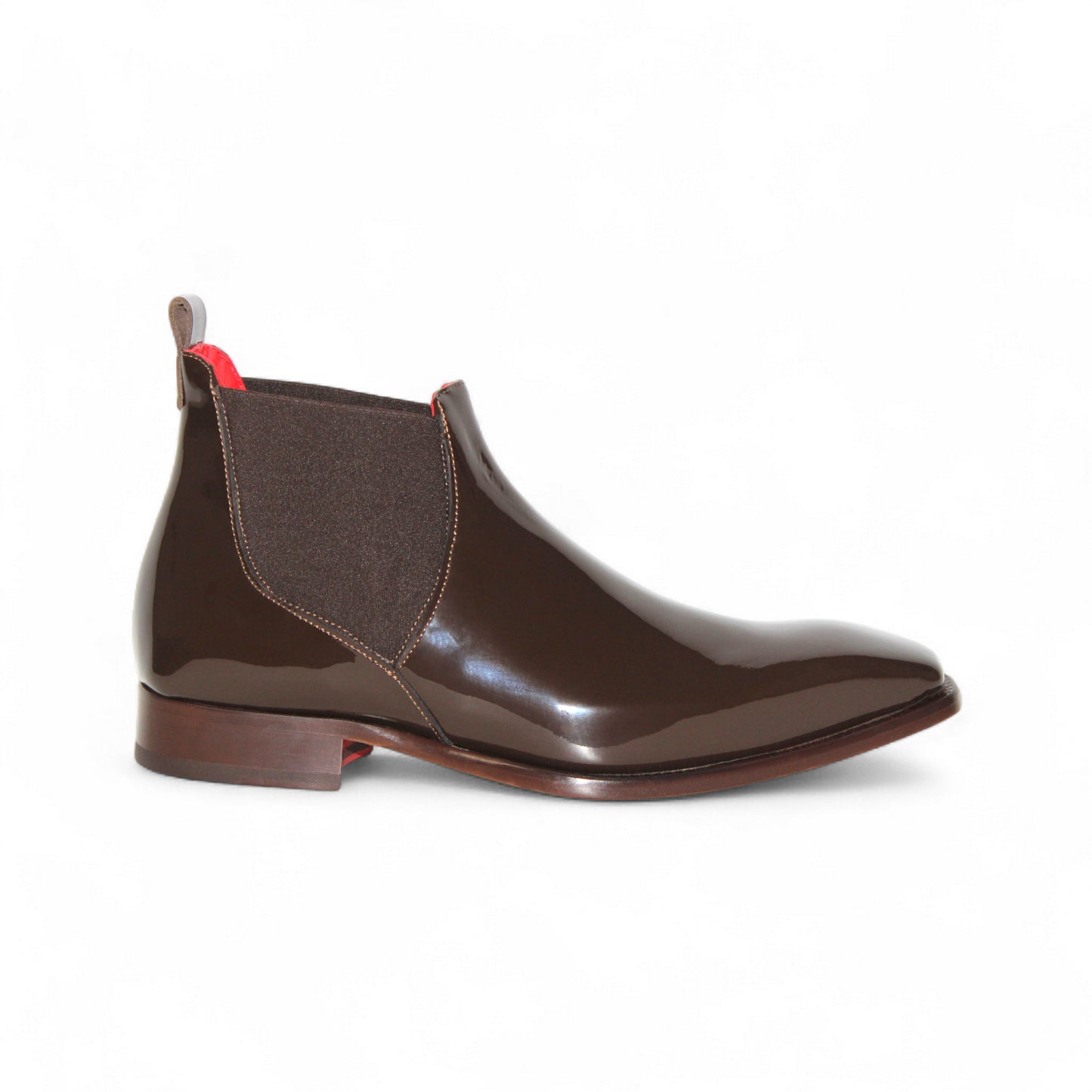The Emilio Franco Leonardo Chocolate, a brown glossy Chelsea boot by Emilio Franco, showcases Italian craftsmanship with elastic side panels, a heel pull tab, and a low wooden heel, presented in side profile on a white background.