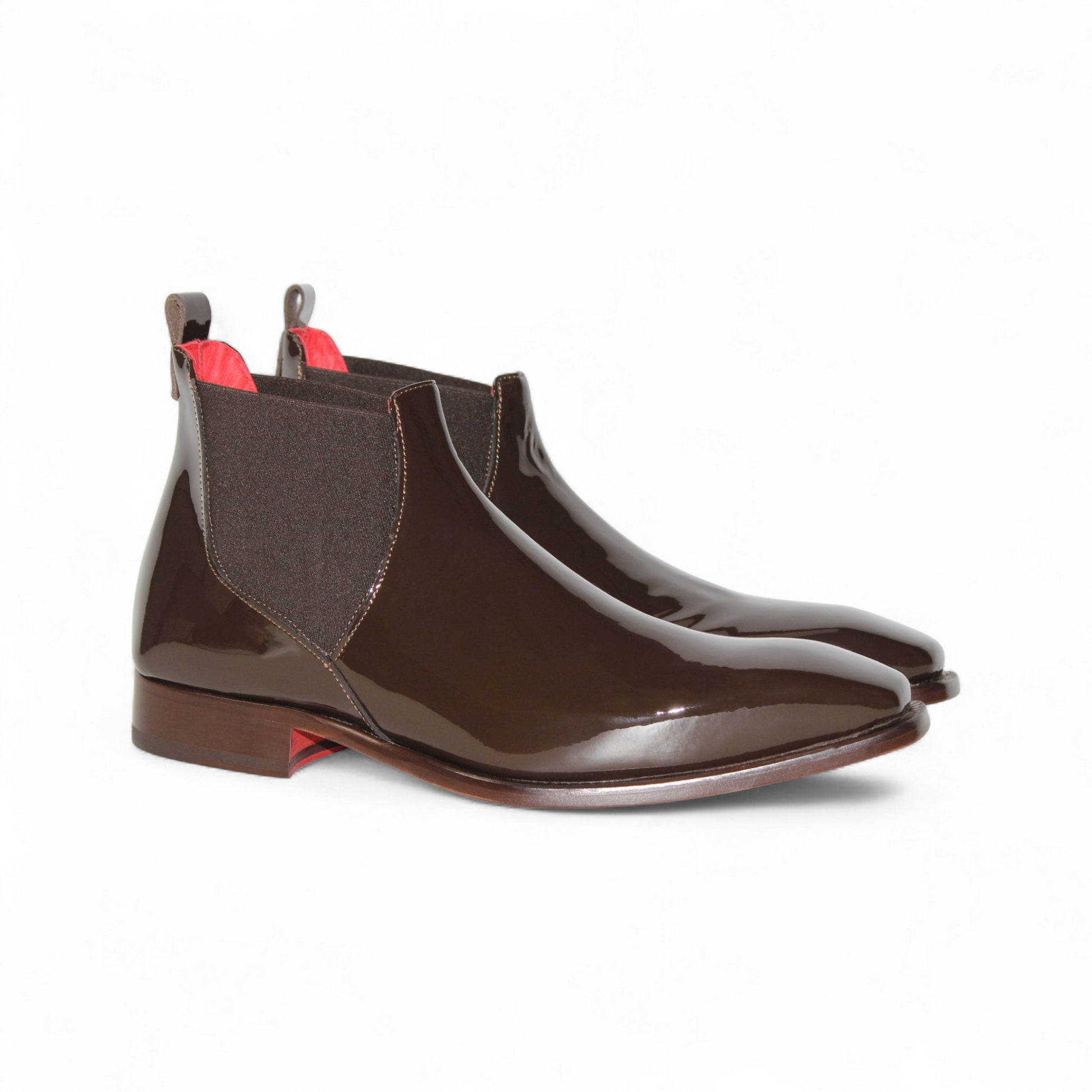 The Emilio Franco Leonardo Chocolate, a brown glossy Chelsea boot by Emilio Franco, showcases Italian craftsmanship with elastic side panels, a heel pull tab, and a low wooden heel, presented in side profile on a white background.