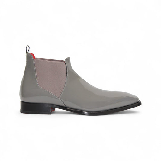 The Emilio Franco Leonardo Grey is a glossy Italian patent leather Chelsea boot with side elastic panels, low black heel, and red accents on the pull tab and lining—luxury formal footwear by Emilio Franco, shown on a white background.