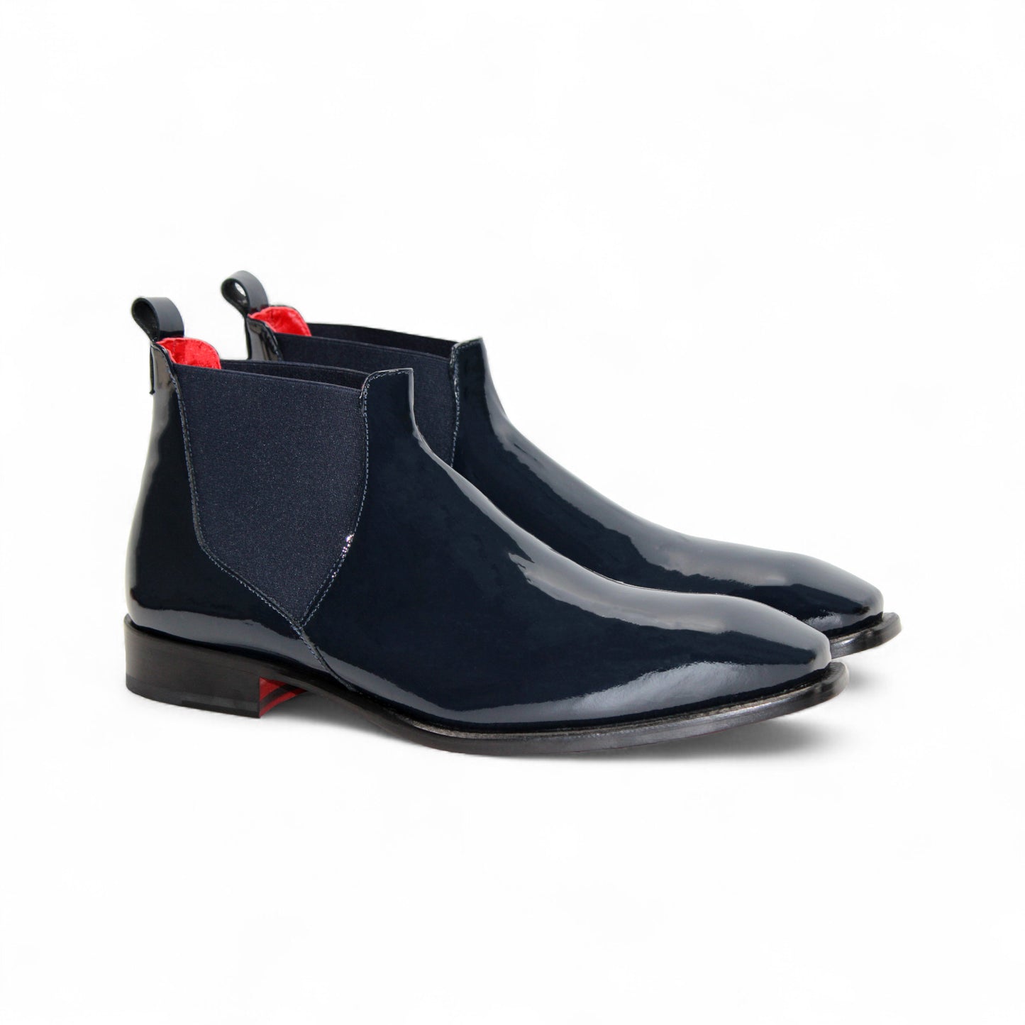 The Emilio Franco Leonardo Navy is a sleek Chelsea boot in navy Italian patent leather with an elastic side panel, low heel, leather sole, and pull tab, displayed in profile against a plain white background.