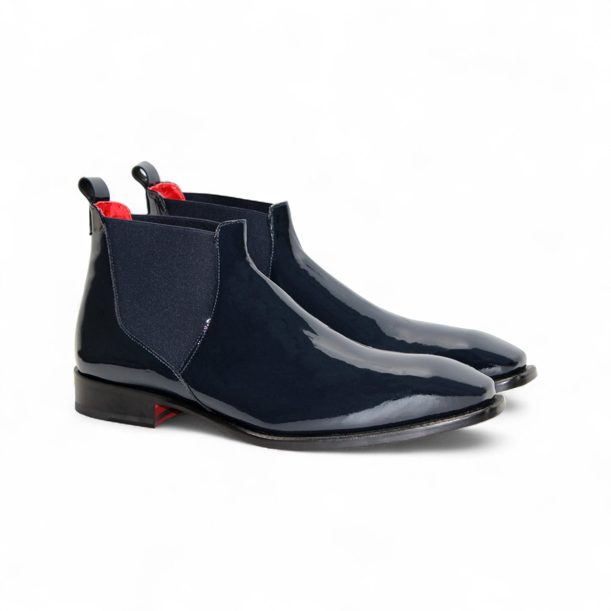 The Emilio Franco Leonardo Navy is a sleek Chelsea boot in navy Italian patent leather with an elastic side panel, low heel, leather sole, and pull tab, displayed in profile against a plain white background.