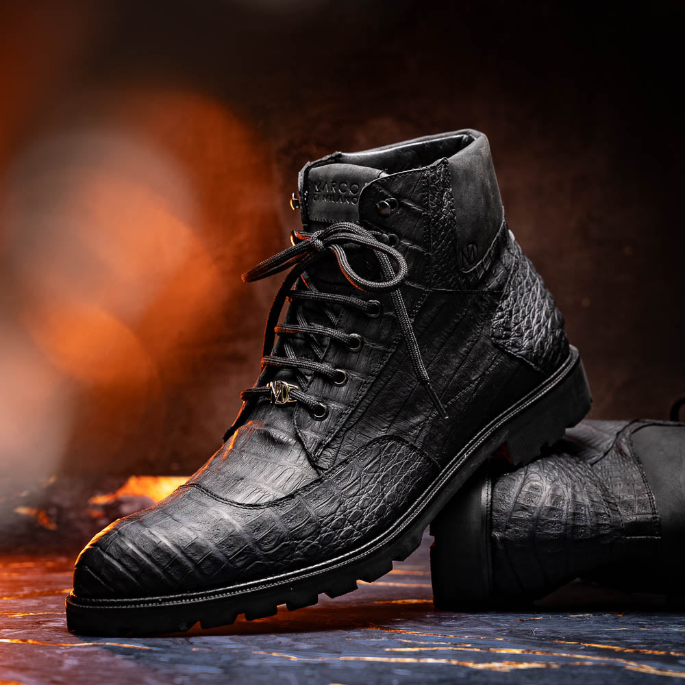 The Leoni Oil Black boots by Marco Di Milano feature genuine caiman leather in a crocodile texture, black laces, and rugged rubber soles—luxurious footwear with striking details.