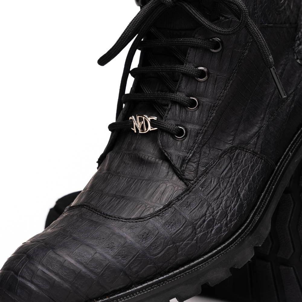 The Leoni Oil Black boots by Marco Di Milano feature genuine caiman leather in a crocodile texture, black laces, and rugged rubber soles—luxurious footwear with striking details.
