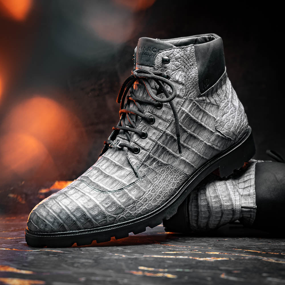 The Leoni Oil Gray boot by Marco Di Milano features a gray, crocodile-patterned design in genuine caiman leather with black laces, a thick rugged sole, and hand-painted finishes—all showcased on a white background.