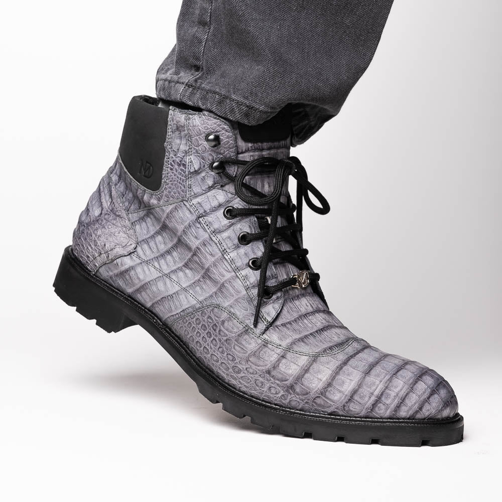 The Leoni Oil Gray boot by Marco Di Milano features a gray, crocodile-patterned design in genuine caiman leather with black laces, a thick rugged sole, and hand-painted finishes—all showcased on a white background.