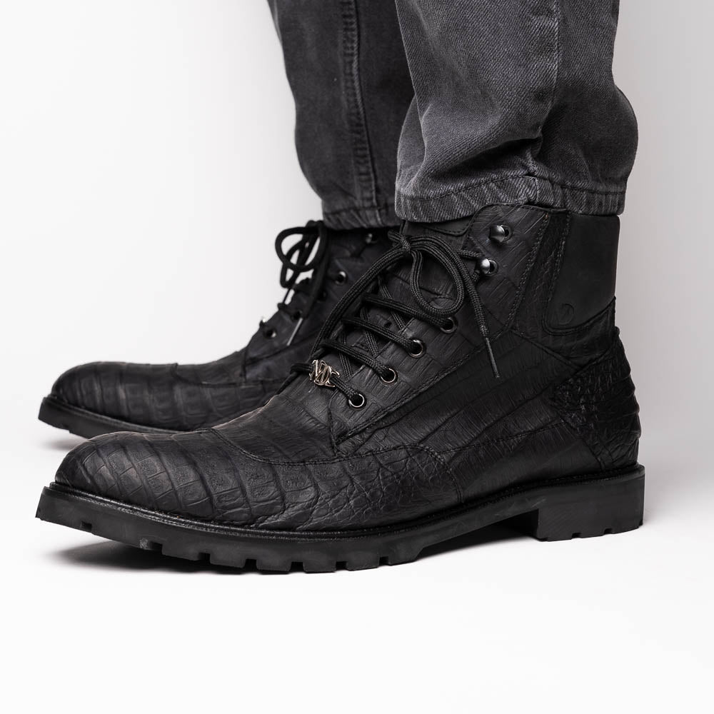The Leoni Oil Black boots by Marco Di Milano feature genuine caiman leather in a crocodile texture, black laces, and rugged rubber soles—luxurious footwear with striking details.