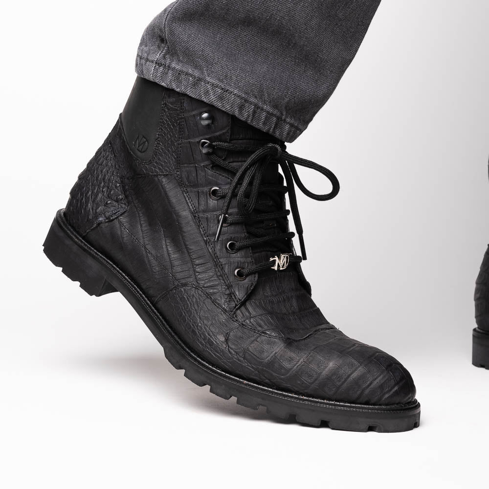 The Leoni Oil Black boots by Marco Di Milano feature genuine caiman leather in a crocodile texture, black laces, and rugged rubber soles—luxurious footwear with striking details.