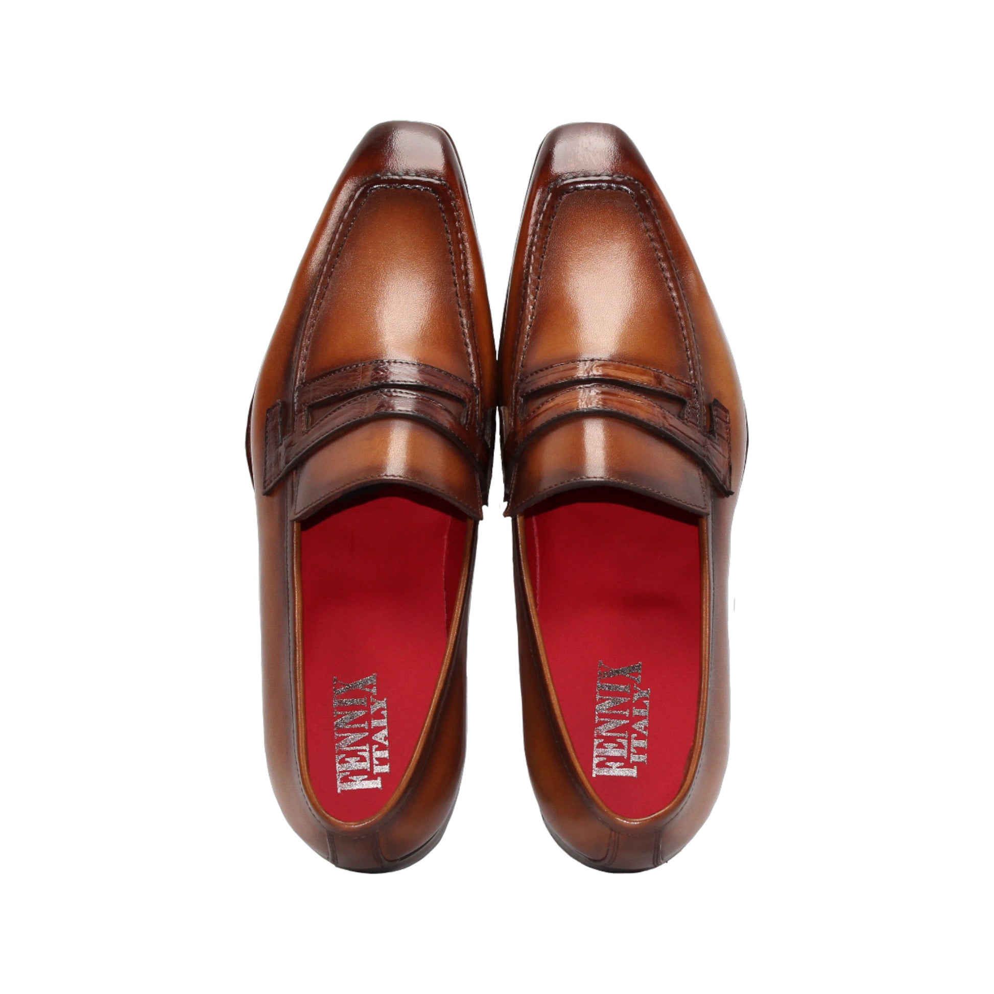 The Fennix of Italy Fennix Liam Cognac is a brown leather loafer with a low heel, penny strap, and red interior lining, expertly crafted in Italy and shown in side profile on a white background.