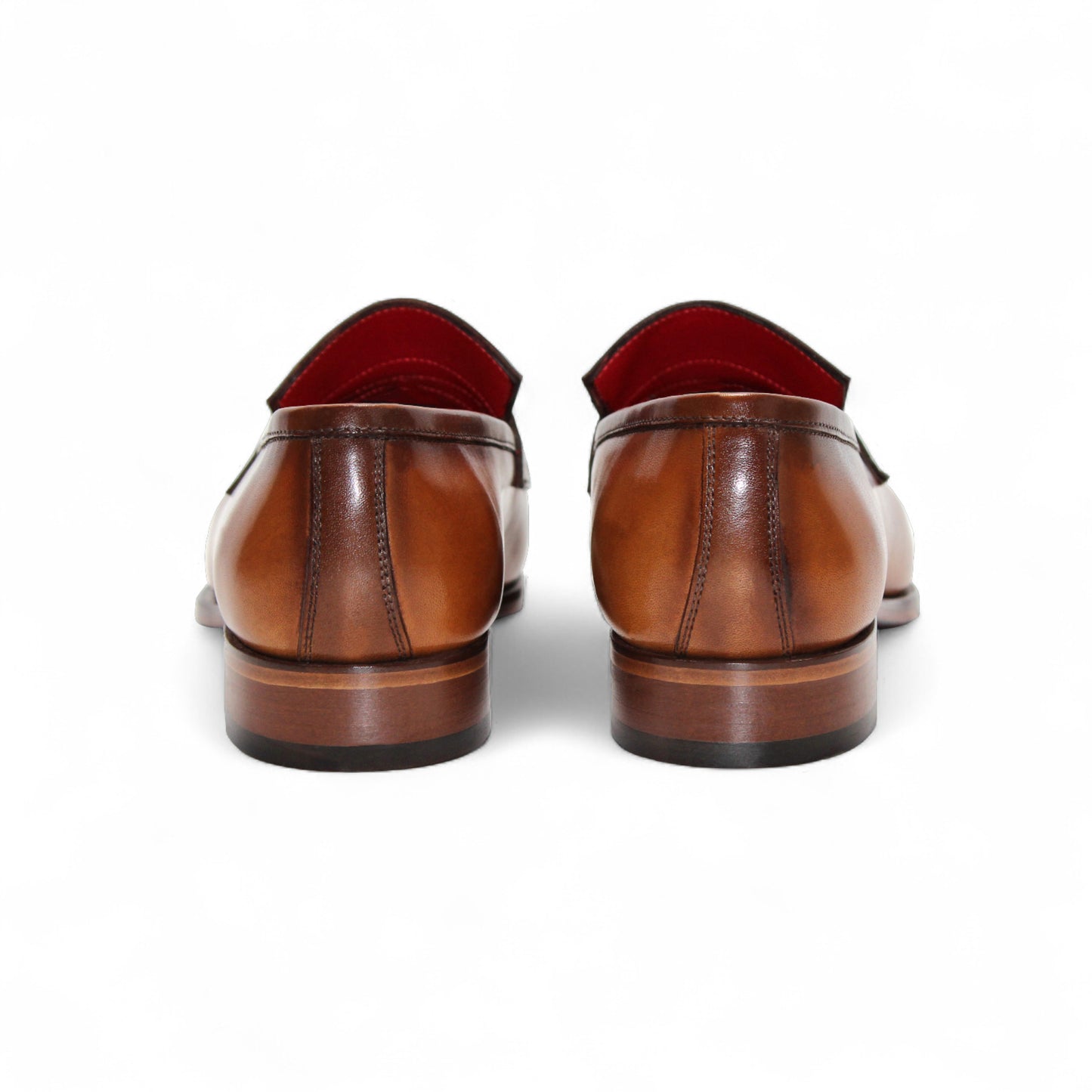 The Fennix of Italy Fennix Liam Cognac is a brown leather loafer with a low heel, penny strap, and red interior lining, expertly crafted in Italy and shown in side profile on a white background.