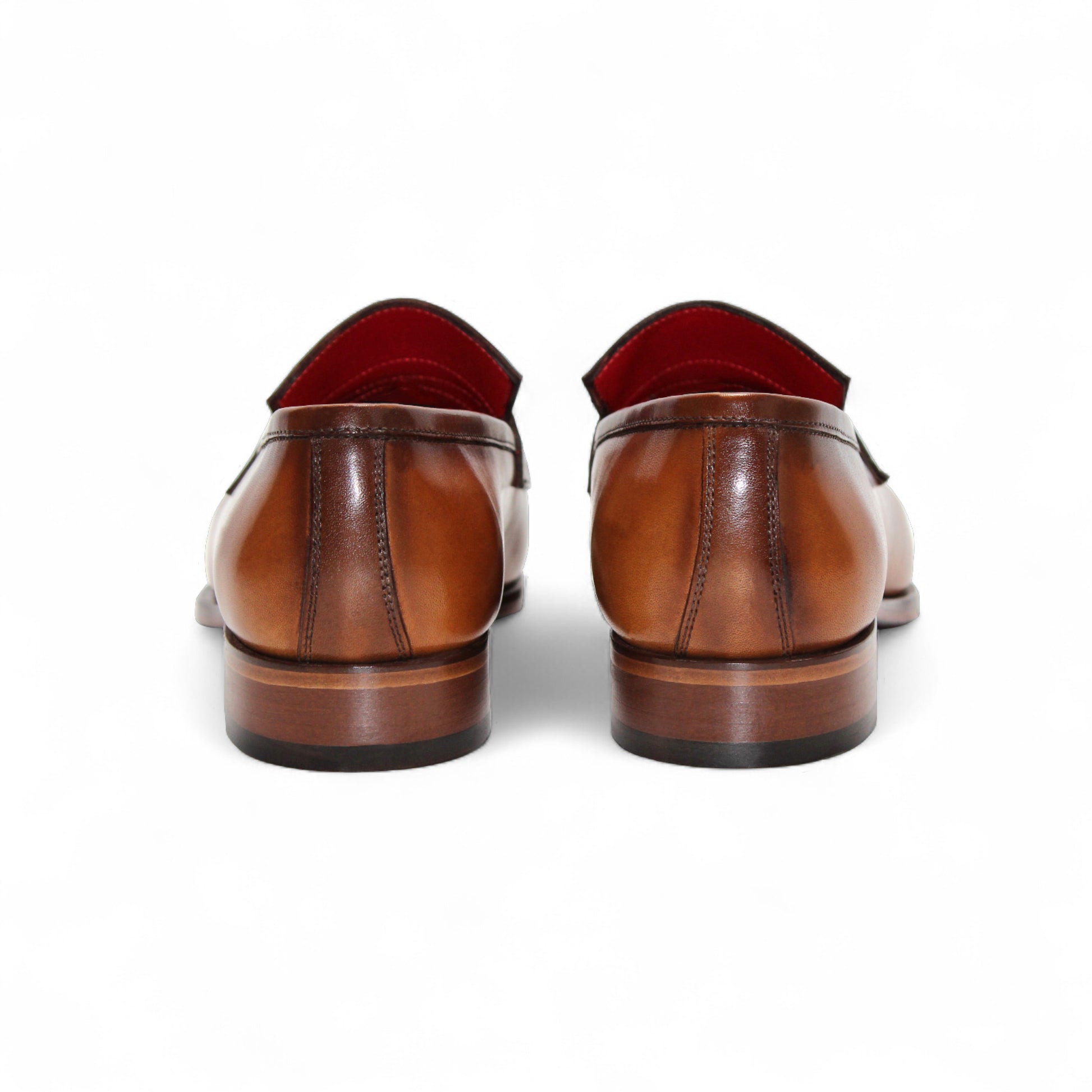 The Fennix of Italy Fennix Liam Cognac is a brown leather loafer with a low heel, penny strap, and red interior lining, expertly crafted in Italy and shown in side profile on a white background.