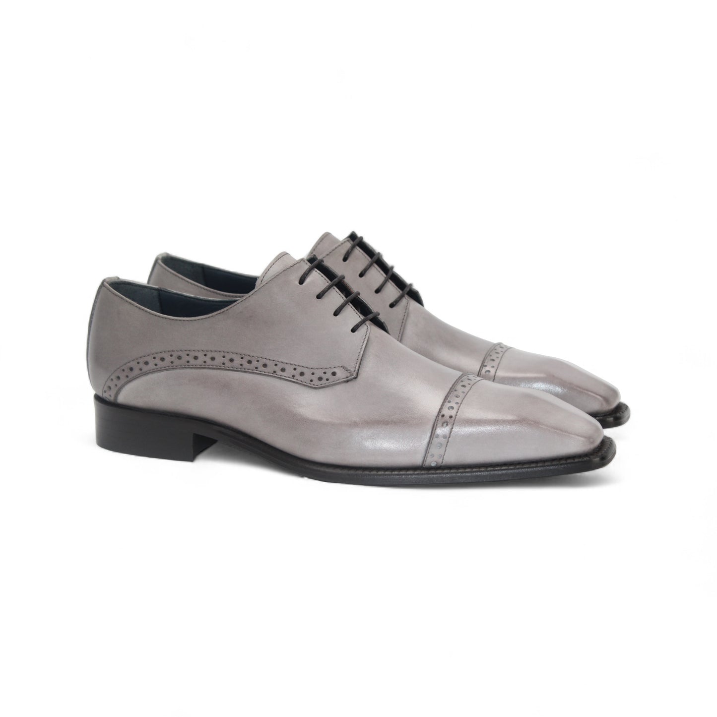 The Duca Lombardi Light Grey by Duca Di Matiste is an Italian-made genuine leather dress shoe with black laces, a low heel, and decorative perforations on the side and toe cap, shown against a white background.