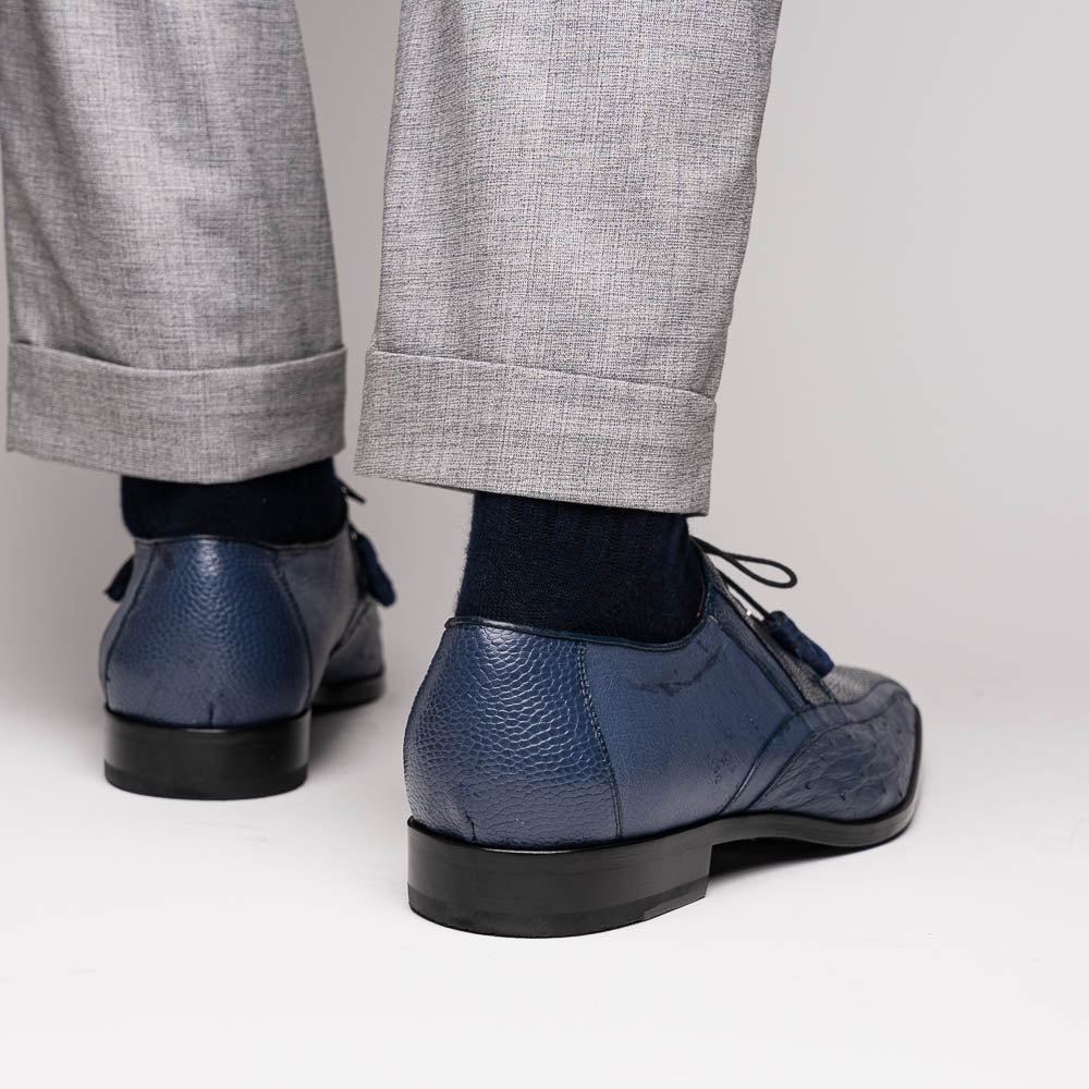 The Lucca Navy by Marco Di Milano: dark blue ostrich dress derby shoes with black soles, lace-up closures, and a textured finish. One shoe stands upright while the other lays on its side, highlighting hand-painted details.