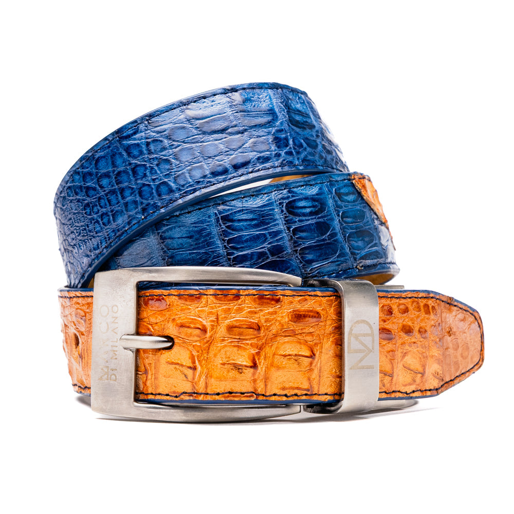 The Luciano Belt in Blue and Brandy by Marco Di Milano—both crafted from genuine caiman leather and adorned with silver buckles—are elegantly coiled together against a white background.