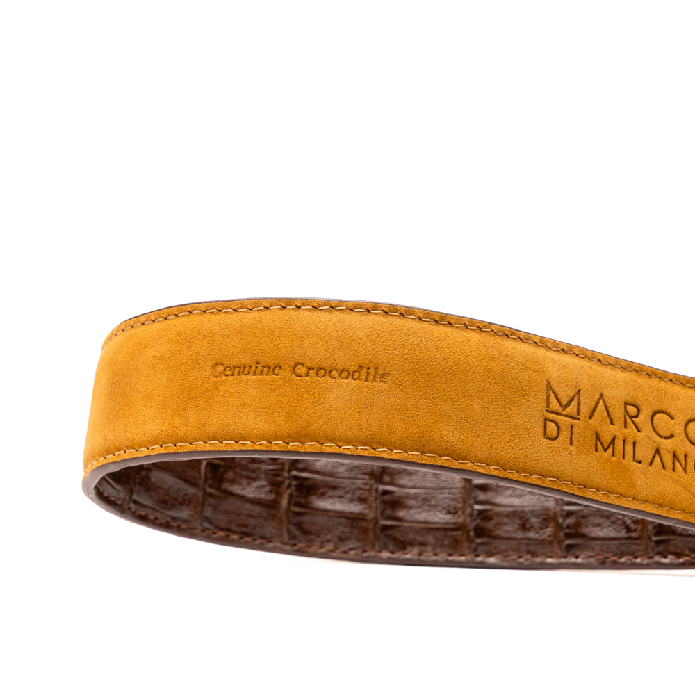 Two handcrafted men’s belts from Marco Di Milano—the Luciano Belt in Brown and Cognac—are coiled and stacked, each highlighted by a silver buckle. These premium accessories showcase the refined elegance and distinctive character of genuine caiman leather, perfect for those who value superior quality.