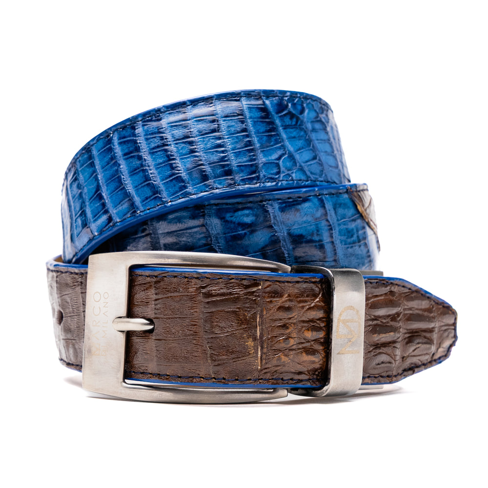 Introducing the Luciano Belt Navy / Brown by Marco Di Milano, a handcrafted luxury belt featuring an exotic crocodile-patterned leather in striking blue and dark brown sections with a refined silver buckle, elegantly coiled on a white background.