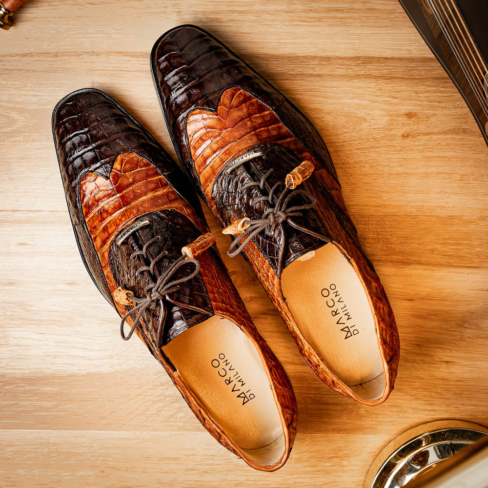 A pair of Marco Di Milano Luciano Brown / Cognac dress shoes with a pointed toe, lace-up closure, and embossed sole branding—ideal for elevating your luxury men's footwear collection.