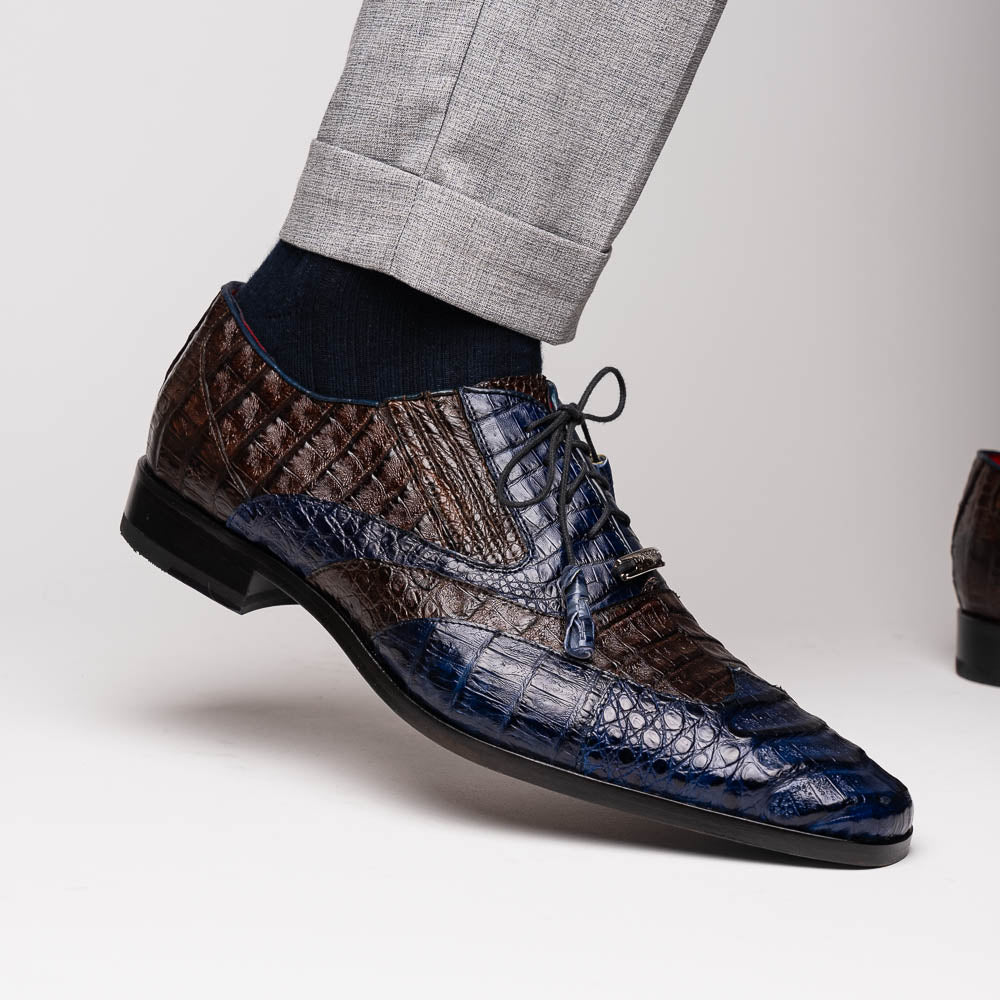 The Luciano Navy / Brown by Marco Di Milano: luxury men's wingtip derby shoes in dark blue and brown genuine caiman, shown upright and on its side to display the branded sole.