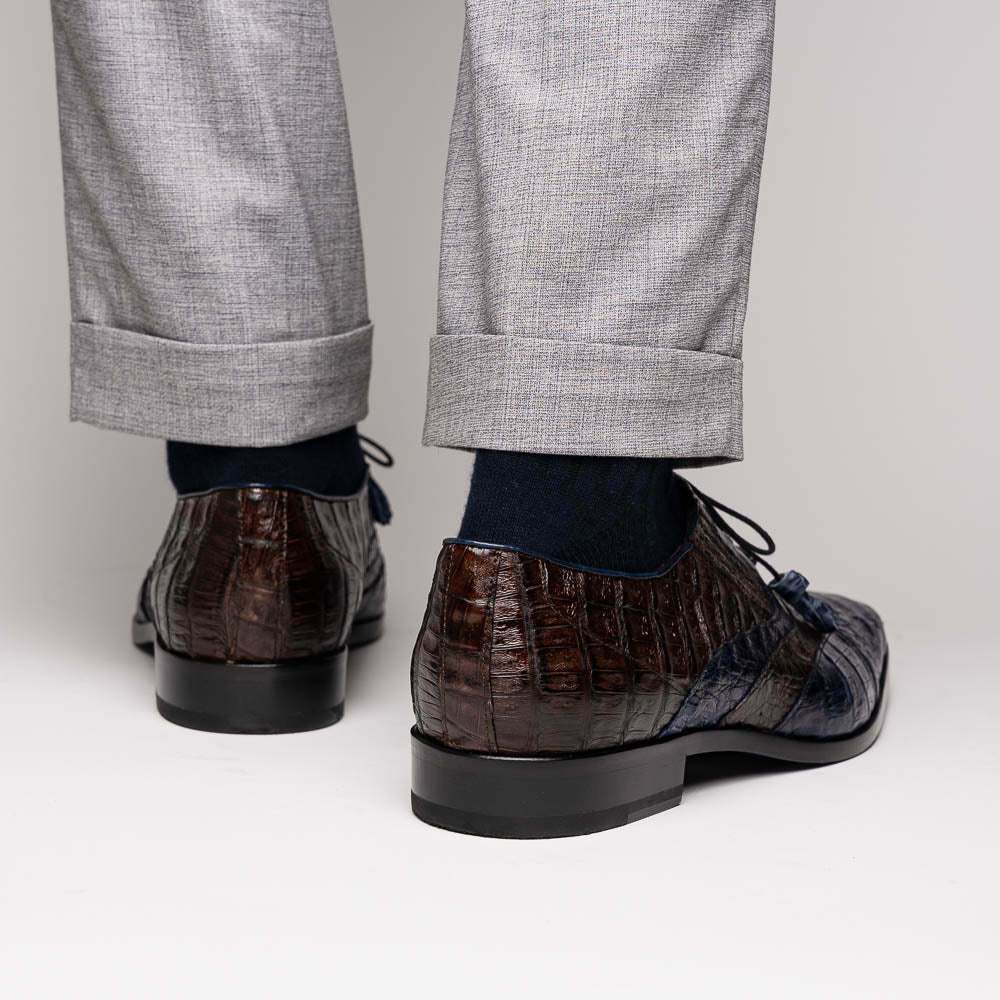 The Luciano Navy / Brown by Marco Di Milano: luxury men's wingtip derby shoes in dark blue and brown genuine caiman, shown upright and on its side to display the branded sole.