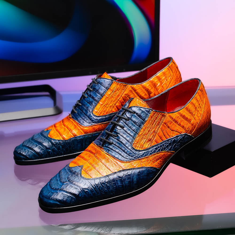 The Marco Di Milano Luciano Blue / Brandy men's dress shoes feature textured leather in orange and navy, with one shoe upright and the other on its side to display the sole.