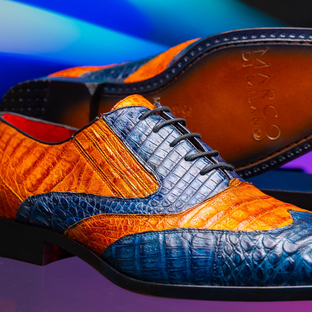 The Marco Di Milano Luciano Blue / Brandy men's dress shoes feature textured leather in orange and navy, with one shoe upright and the other on its side to display the sole.