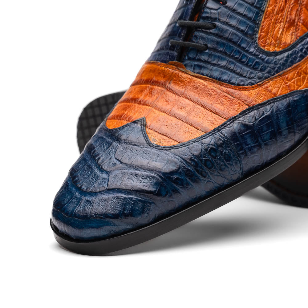 The Marco Di Milano Luciano Blue / Brandy men's dress shoes feature textured leather in orange and navy, with one shoe upright and the other on its side to display the sole.