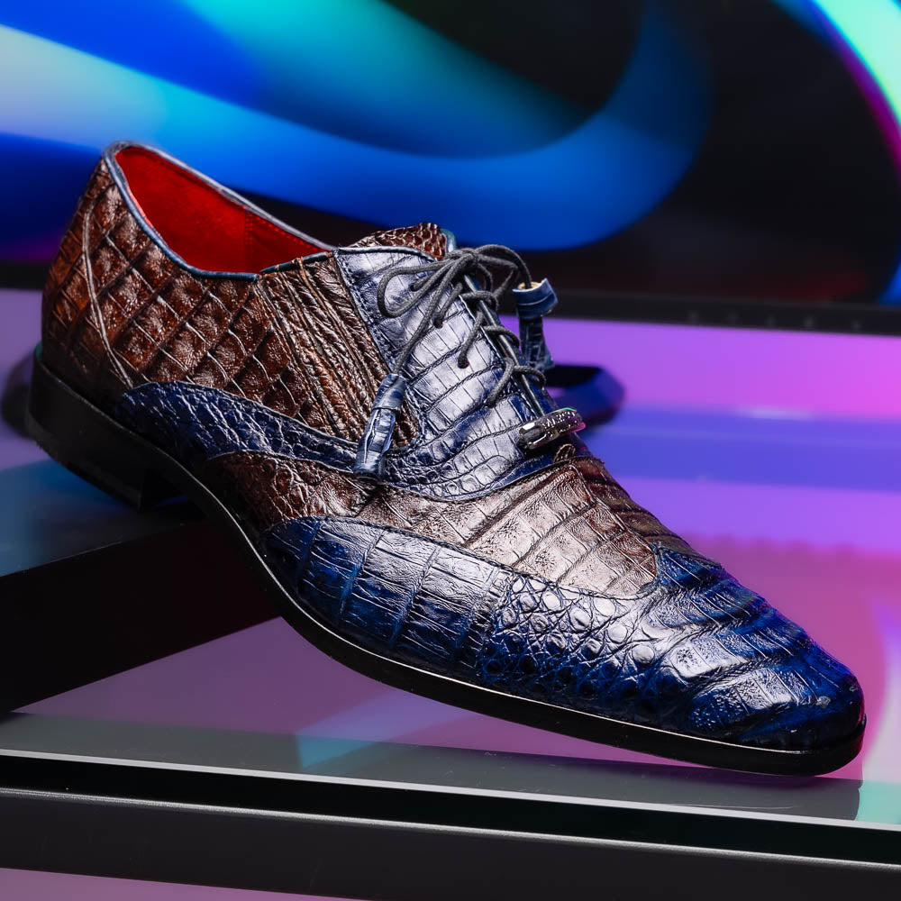 The Luciano Navy / Brown by Marco Di Milano: luxury men's wingtip derby shoes in dark blue and brown genuine caiman, shown upright and on its side to display the branded sole.