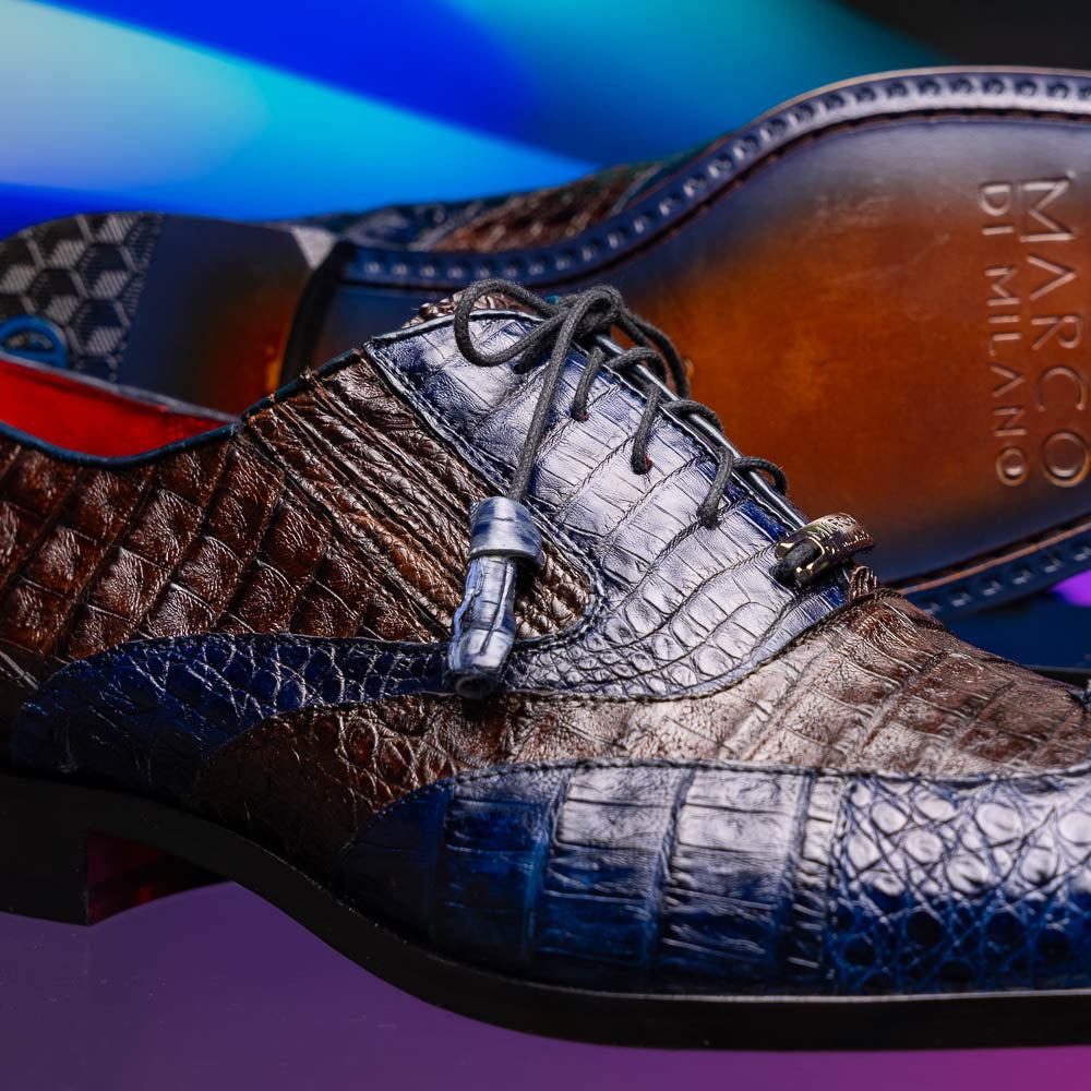 The Luciano Navy / Brown by Marco Di Milano: luxury men's wingtip derby shoes in dark blue and brown genuine caiman, shown upright and on its side to display the branded sole.