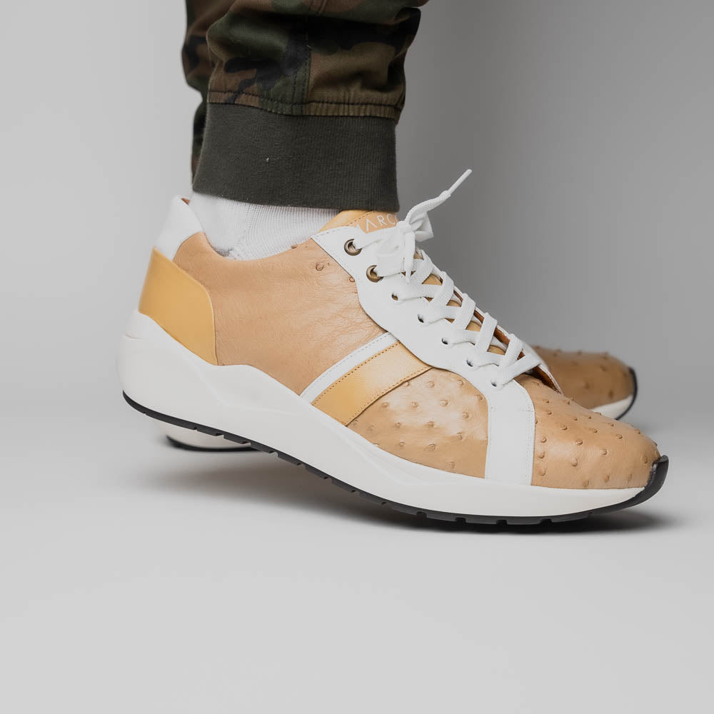 The Marco Di Milano Lyon II Orix / White sneakers feature beige and white ostrich quill-textured uppers and black rubber soles—an ideal choice for those seeking luxury footwear.
