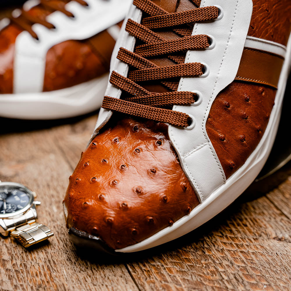 The Lyon II Brandy / White sneakers by Marco Di Milano feature a textured brown and white leather upper, white soles, and brown laces—a true statement in luxury footwear, shown against a plain white background.
