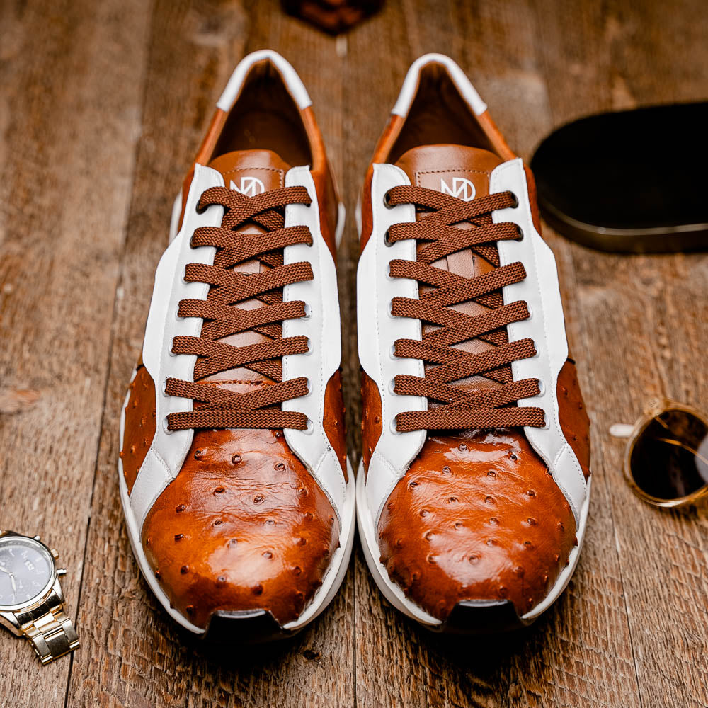 The Lyon II Brandy / White sneakers by Marco Di Milano feature a textured brown and white leather upper, white soles, and brown laces—a true statement in luxury footwear, shown against a plain white background.
