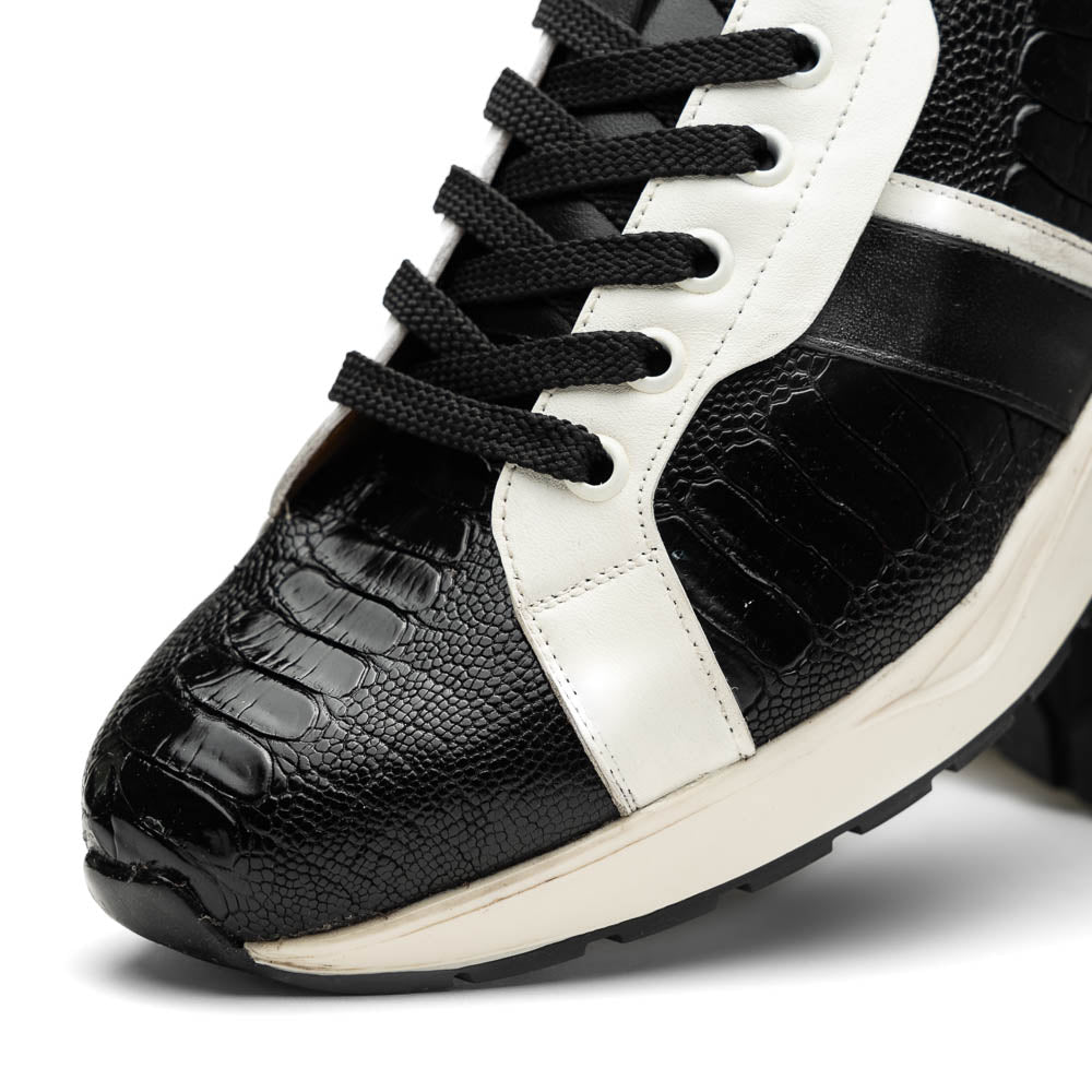 The Marco Di Milano Lyon Black / White sneakers feature a hand-painted, textured pattern, black laces, and rubber soles—one shoe shown upright, the other propped behind.