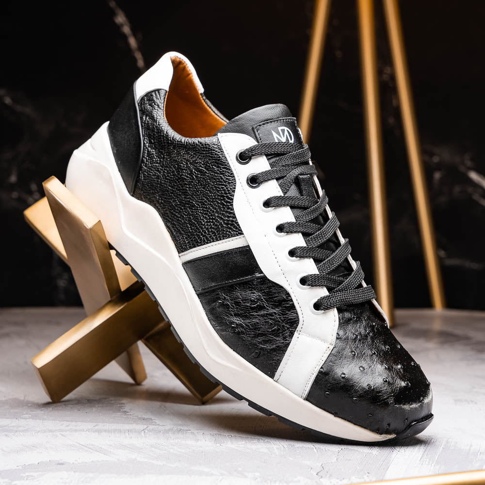 The Marco Di Milano Lyon Black / White sneakers feature a hand-painted, textured pattern, black laces, and rubber soles—one shoe shown upright, the other propped behind.