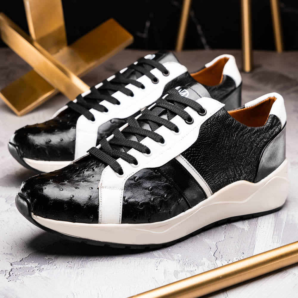 The Marco Di Milano Lyon Black / White sneakers feature a hand-painted, textured pattern, black laces, and rubber soles—one shoe shown upright, the other propped behind.