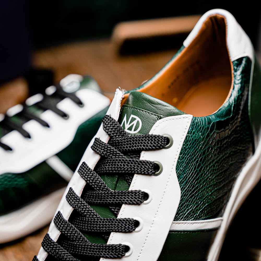 The Marco Di Milano Lyon Green / White sneakers feature green and white genuine ostrich leather with texture, black laces, and white rubber soles—one shoe stands upright while the other leans against it.