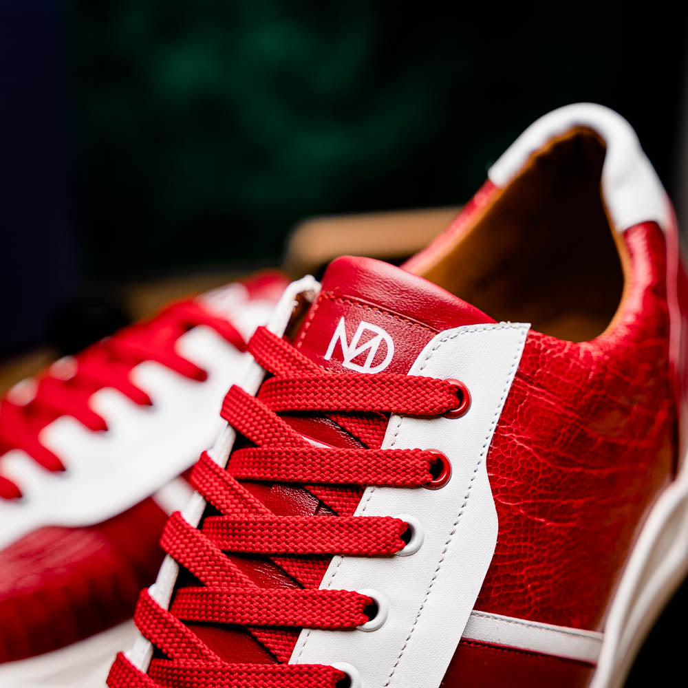 The Marco Di Milano Lyon Red / White are luxury low-top sneakers featuring a hand-painted finish, textured leather, white soles, red laces, and black tread, showcased on a plain white background.