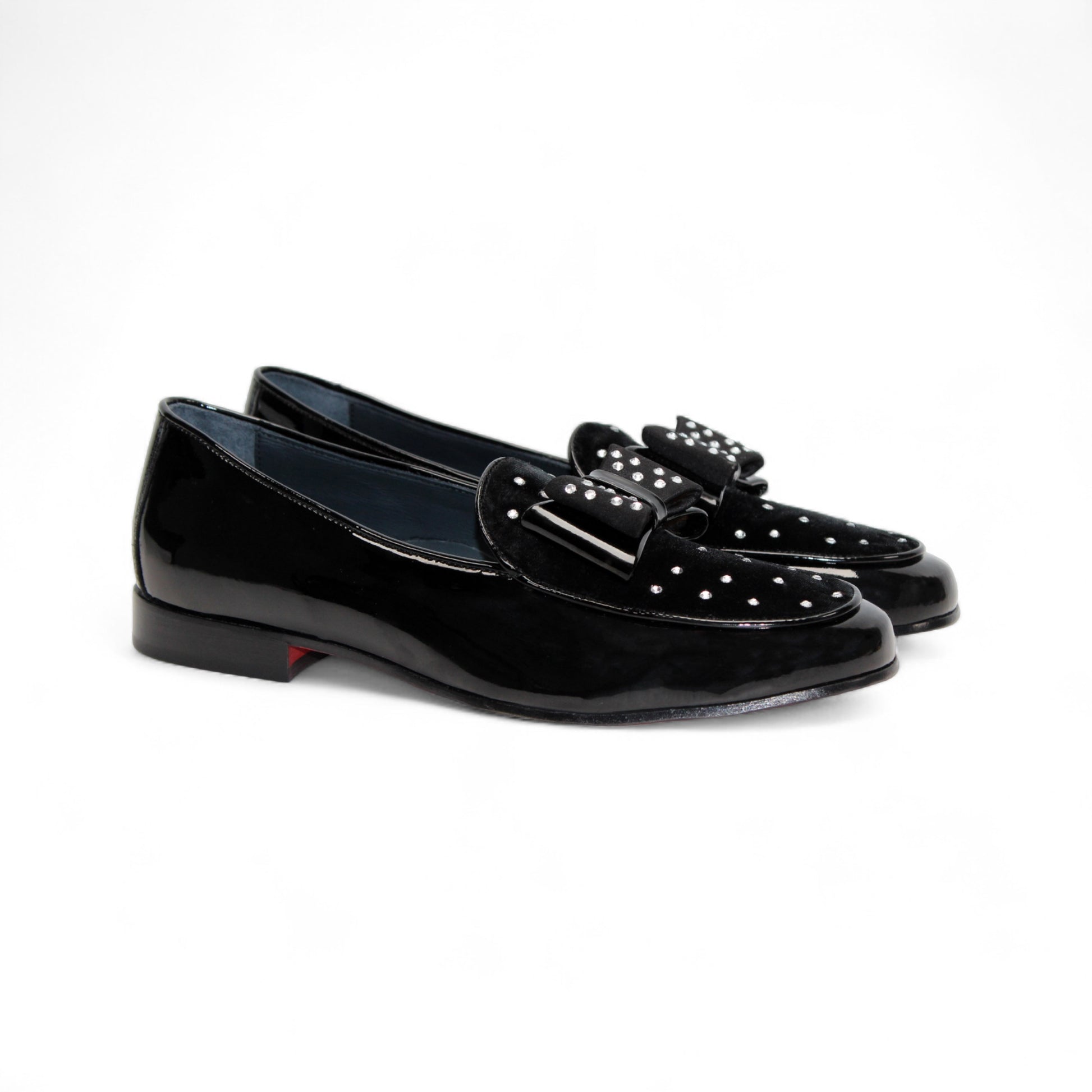 The Duca Maratea Black by Duca Di Matiste is a black patent leather loafer with a low heel, suede strap, and metal studs, highlighting fine Italian craftsmanship against a white background.