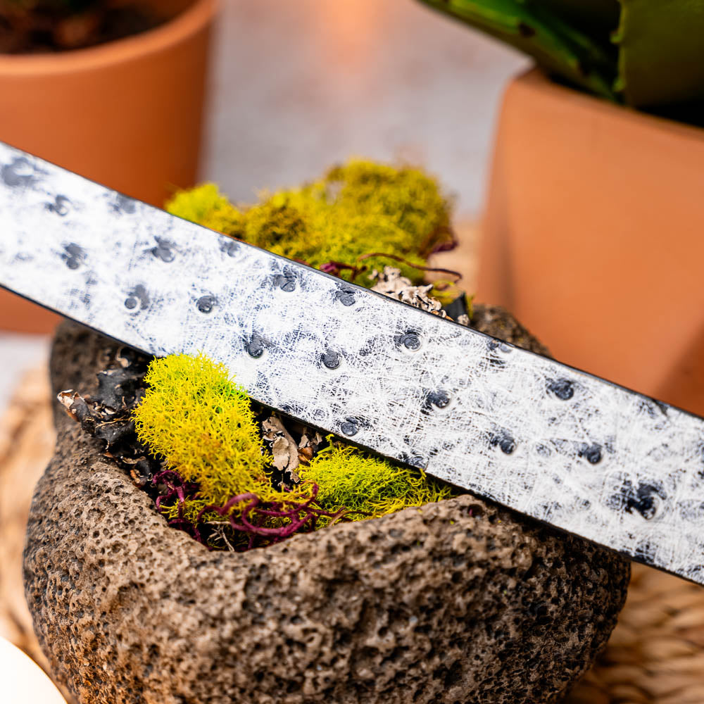 The Domenico Belt Antique Newspaper by Marco Di Milano features white and black textured leather, a silver engraved buckle, and a visible "MD" logo—reflecting the brand’s signature luxury craftsmanship.