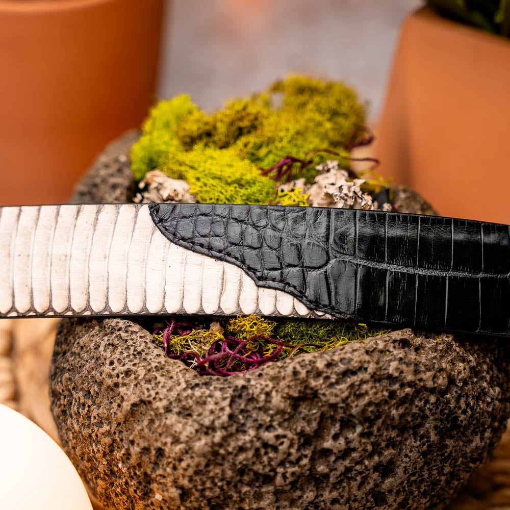 The Moncalieri Belt Bone / Black by Marco Di Milano features a textured white outer and black crocodile pattern by a silver buckle, mirroring the elegance of alligator and cobra skin to complement luxury footwear.