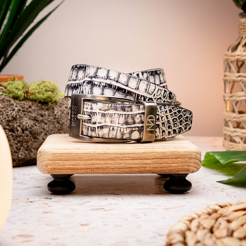 Here’s a rewritten sentence using your product data: The Silvio Belt Antique Newspaper by Marco Di Milano is a black and white genuine caiman belt with a crocodile pattern, finished with a silver buckle engraved with “Marco Di Milano.”.