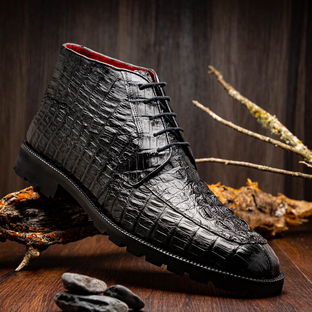 The Marco Di Milano Martinelli Black boots feature crocodile-patterned leather and thick rubber soles—one upright, one sideways to show the tread—for standout men's exotic footwear.