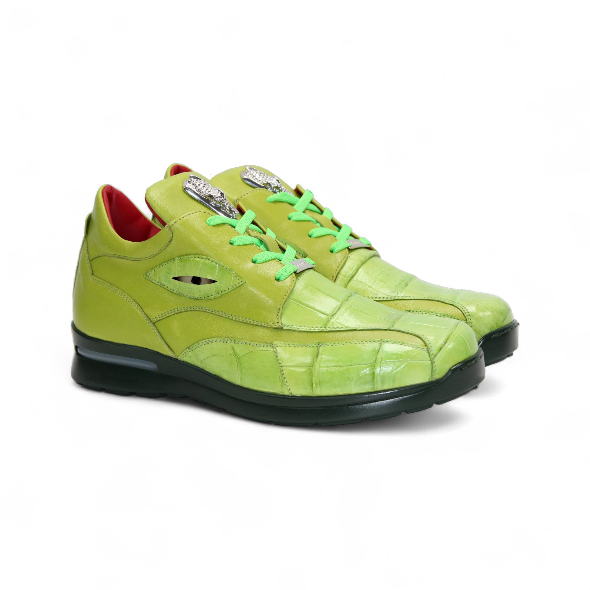 The Fennix Mason Green by Fennix of Italy is a bright green sneaker with a reptile-skin pattern, light green laces, black sole, and a distinctive oval-shaped eyelet detail on the side—an ode to classic Italian alligator shoes.