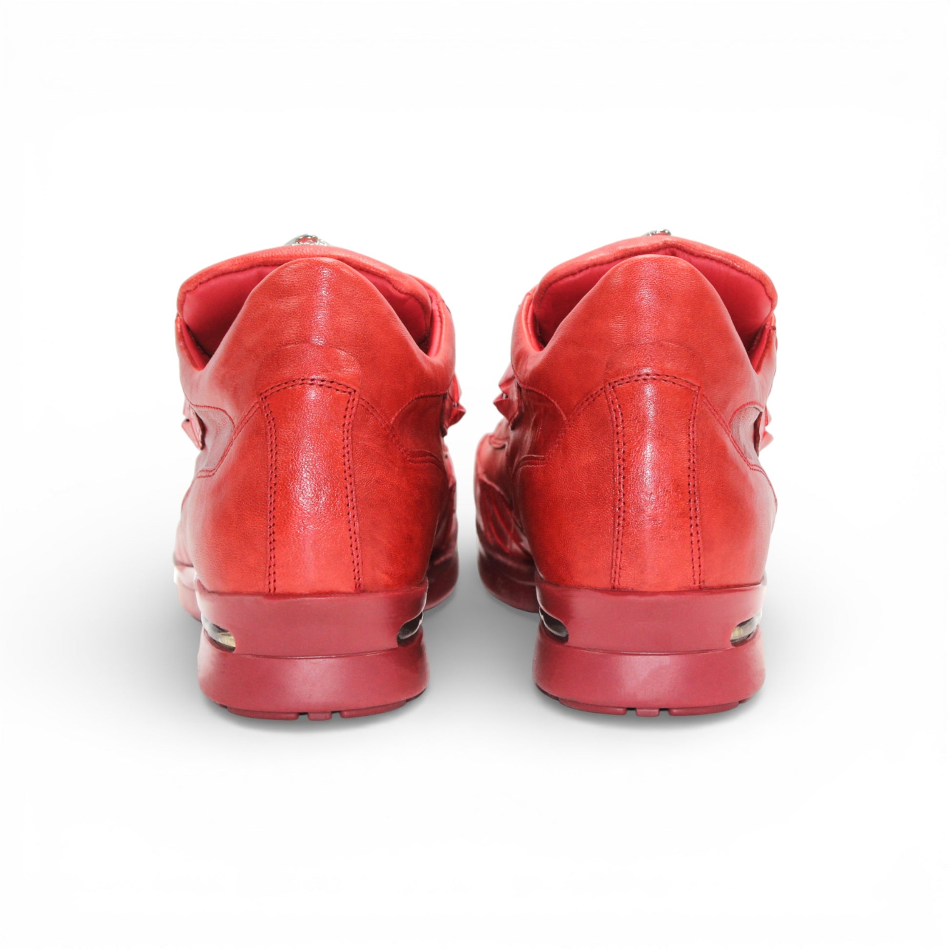 The Fennix Mason Red by Fennix of Italy is a modern red leather athletic shoe with laces and a tongue emblem, displayed in side profile on a white background.