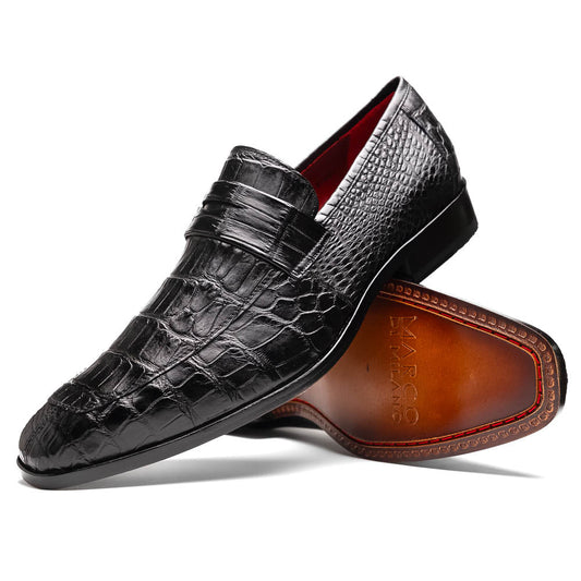 The Matteo Black by Marco Di Milano is a pair of black genuine alligator slip-on shoes with a polished brown leather sole, embossed branding, and hand-painted finishes, shown against a white background.