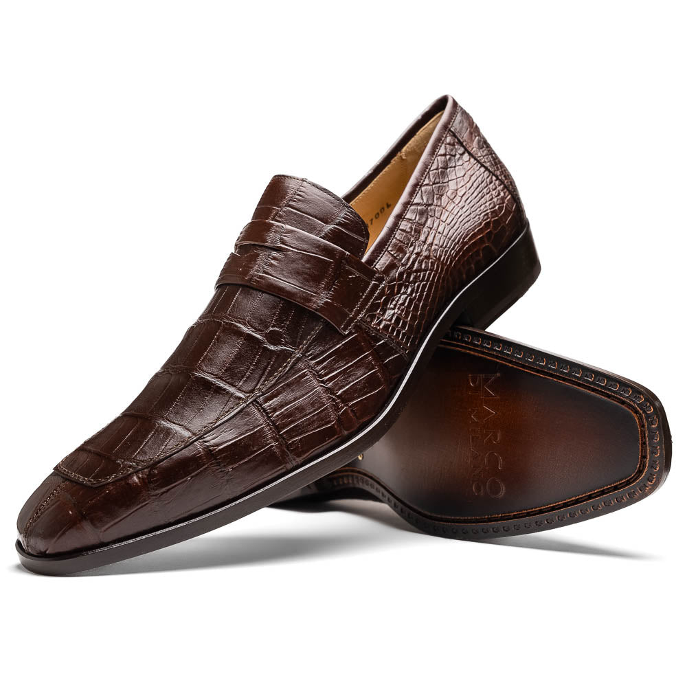 The Matteo Brown by Marco Di Milano is a pair of brown luxury loafers with a crocodile pattern; one shoe lies flat while the other is propped to showcase the sole and elegant hand-painted finishes.